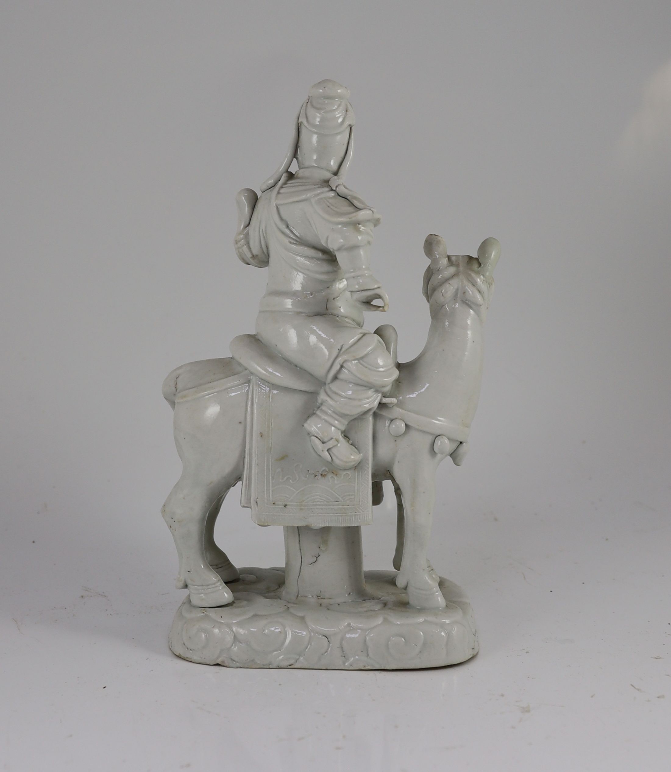 A Chinese blanc-de-chine equestrian group of Guandi seated astride a horse, Dehua kilns, Kangxi period, 30cm high, minor faults